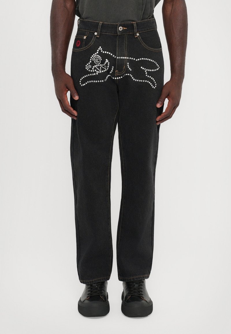 Sorte denim jeans har et hånd- og rose-design i rhinesteiner på venstre side, med klassisk fem-lommestil og kontraststing.