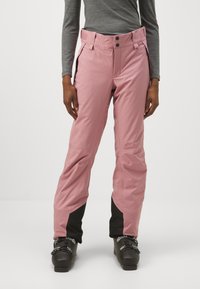 Pantalons de ski roses imperméables avec accents noirs, présentant une taille haute, une fermeture à bouton en métal et des poches latérales. Le matériau semble lisse et durable.