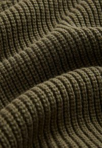 Olivovozelená pletená látka s rebrovanou textúrou, ktorá obsahuje mäkké, hrubé vlákna vytvárajúce konzistentný vzor po celom povrchu.