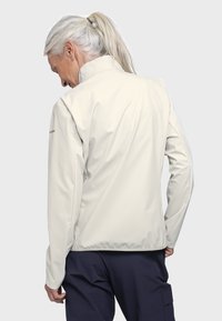 Hellbeige wasserdichte Jacke mit hohem Kragen, taillierter Passform und elastischen Bündchen. Glatte Textur; mit einem Logo auf der Schulter.