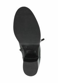 Zapato de cuero negro con suela de goma plana, que presenta una puntera redondeada, textura lisa y un diseño minimalista, incluyendo cierre con cremallera lateral.