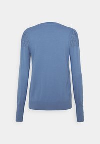 Blå stickad tröja med långa ärmar, rund halsringning och mönstrad detaljering på axlarna. Slät textur, tight nederkant.