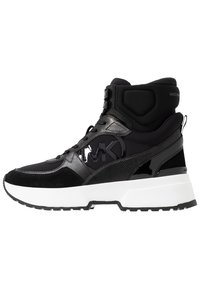 Černý vysoký teniska s kombinací hladkých a texturovaných materiálů, výrazné logo na straně a bílá gumová podrážka.