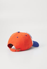 Oransje baseballcap med blå skjerm, med en hvit frontpanel og blå detaljer. Inkluderer en justerbar stropp bak.