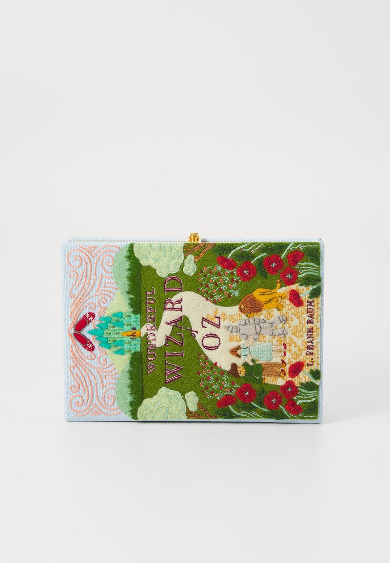 Siuvinėta rankinė su spalvingomis vaizdais, vaizduojanti žalias kraštovaizdis, gėles ir pavadinimą "Nuostabus Oz burtininkas" ryškiu šriftu.