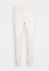 Beige slim-fit joggingbyxor med elastisk midja och muddar, tillverkade av mjukt tyg som passar för vardagsbruk.
