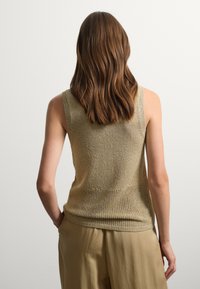 Khaki tanktop met een gestructureerd breipatroon, met een losse pasvorm, brede straps en een lagere mesh-inzet op de rug.
