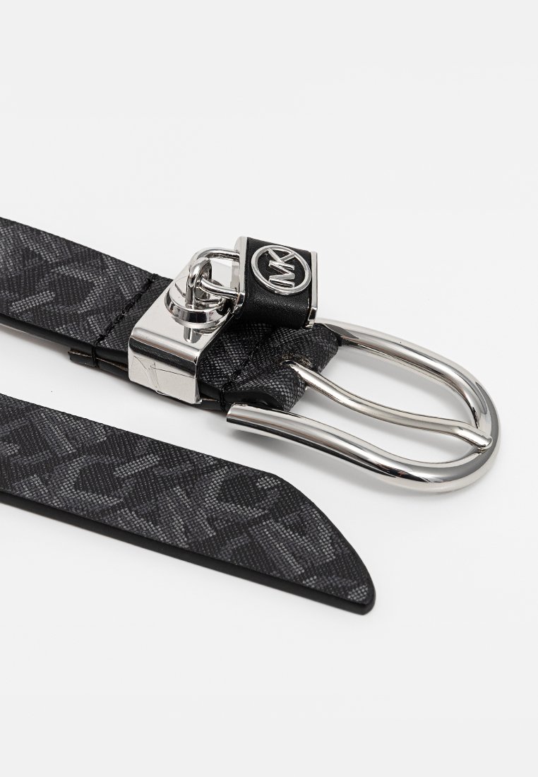 Ceinture noire à motif avec une boucle en métal argenté. Comprend une sangle texturée et un accent de logo circulaire sur la boucle.