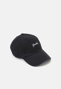 Schwarze Baseballkappe aus Baumwolle mit gebogenem Schirm. Mit weißer "Yankees"-Stickerei auf der Vorderseite und Belüftungsöffnungen.