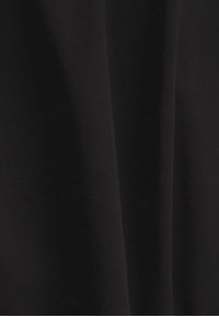 Tissu noir avec une subtile texture diagonale et des plis ombragés créant de douces lignes verticales.