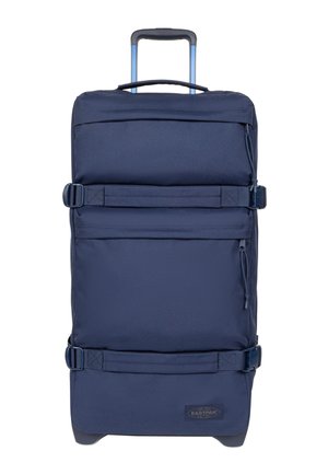Grande valigia blu navy con ruote, due cinghie laterali regolabili, una maniglia superiore e una maniglia telescopica estraibile.