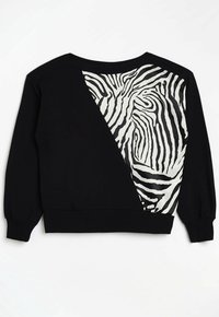 Felpa nera con maniche lunghe. Presenta un pannello diagonale di tessuto zebrato in bianco e nero sulla schiena. Orlo e polsini a coste.