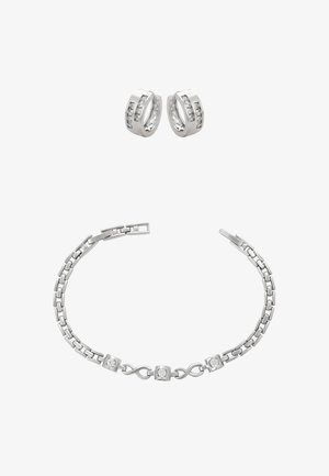 Ezüst karkötő, láncszemes kialakítással és cirkónia díszítéssel, hozzáillő, kövekkel ékesített karikafülbevalókkal.