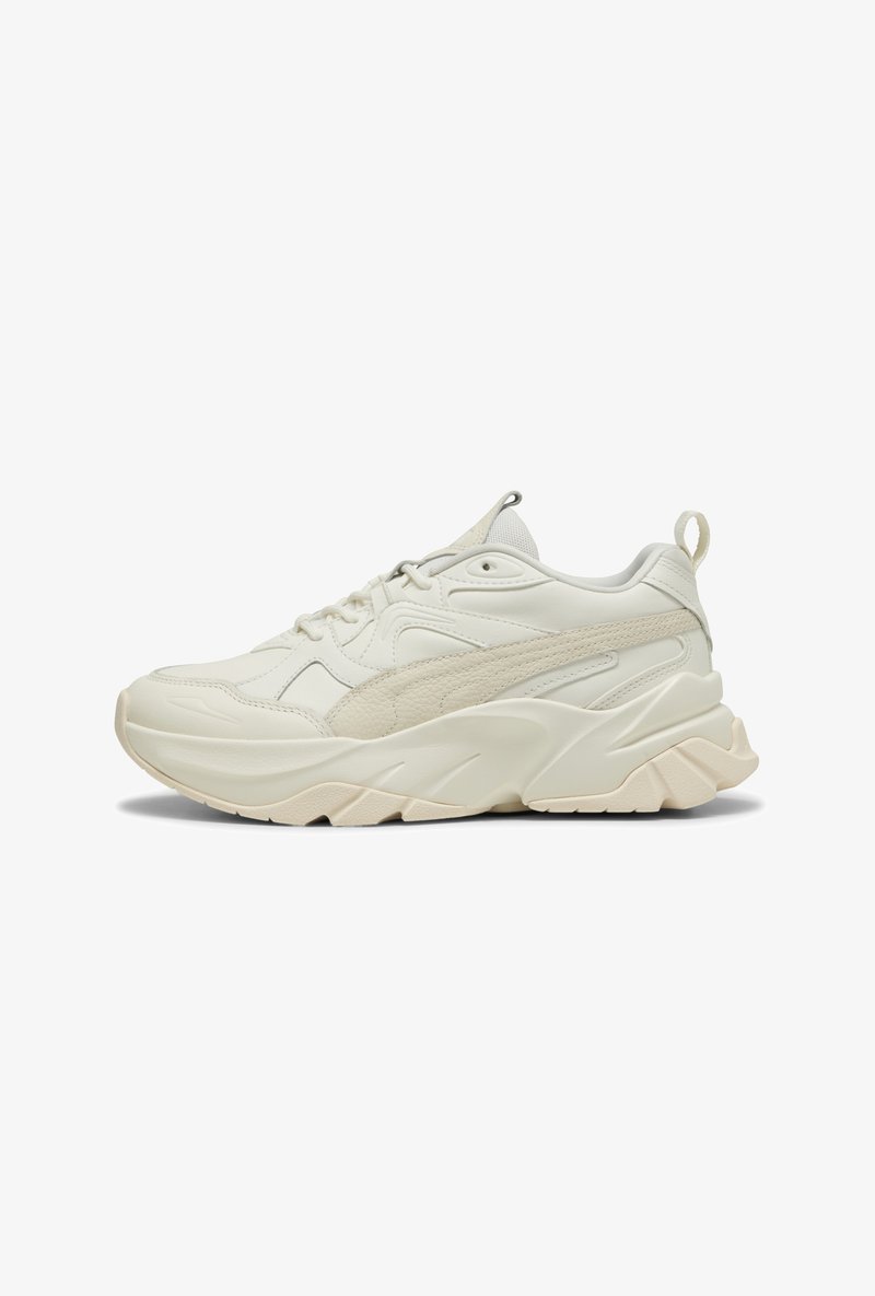 Grube białe sneakersy z mieszanką gładkiej i fakturowanej skóry, grubą podeszwą oraz pętelką przy pięcie dla łatwego zakładania.