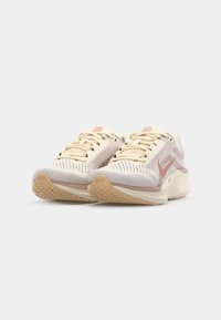 Lichtgewicht hardloopschoenen in crème en roze, met een ademende mesh bovenkant, rubberen zool en gestructureerde accenten voor extra grip.