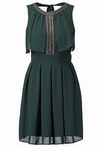 Robe sans manches vert foncé avec jupe plissée, surpiqûres transparentes sur le corsage, col brodé métallique et fermeture par lien à l'arrière du cou.