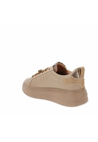 Zapatillas beige con parte superior de cuero liso, puntera redondeada y parte trasera decorativa reforzada con oro. Suela de goma gruesa para mayor altura.