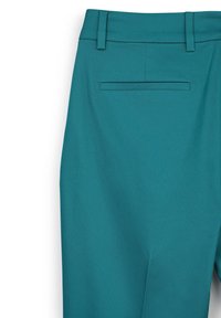 Pantalon ajusté couleur sarcelle avec une texture de tissu lisse, doté d'une poche arrière et de passants de ceinture, conçu dans une silhouette à jambe droite.