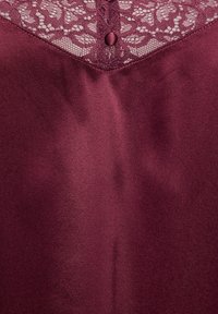 Burgundy nightgown featuring a lace yoke with a round button closure, smooth satin fabric, and a soft, matte texture.