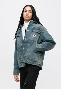 Τζιν μπουφάν σε ξεθωριασμένο μπλε χρώμα με μεγάλες τσέπες στο στήθος, ασημένια κουμπιά και λογότυπο σε ταμπέλα. Διαθέτει άνετη εφαρμογή και κανονικό γιακά.