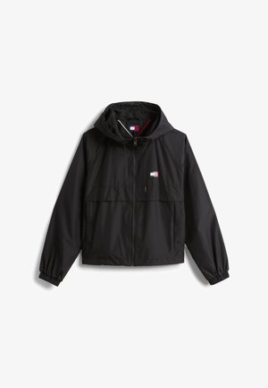 Melna jaka ar rāvējslēdzēju un kapuci. Izgatavota no viegla materiāla, piedāvā elastīgas aproces un logotipa uzšuvumu kreisajā krūtī.