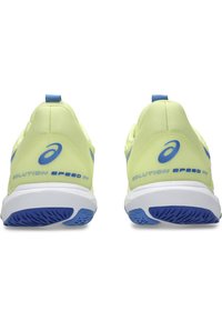 Chaussures de sport jaune clair avec des accents bleus, présentant une tige en maille texturée, un col rembourré et une semelle blanche avec une semelle extérieure à motif.