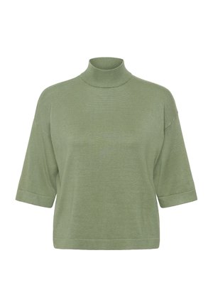 Gebreide groene coltrui met korte opgerolde mouwen. Zachte textuur, ontspannen pasvorm en minimale naden op een witte achtergrond.