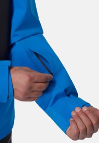 Blue waterproof jacket with a black inner lining, featuring a zippered pocket on the sleeve and textured fabric for durability.