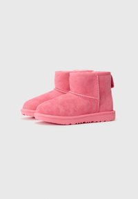 Bottes à chevilles en daim rose avec une doublure intérieure douce, un bout arrondi et une semelle en caoutchouc plate. Dotées de détails cousus et d'une languette à l'arrière.