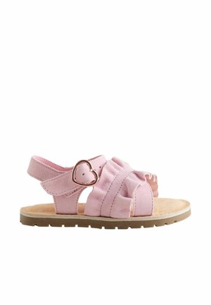 Pink toddler sandal with heart-shaped buckle, ruffled straps, cushioned insole, and flat rubber sole.
