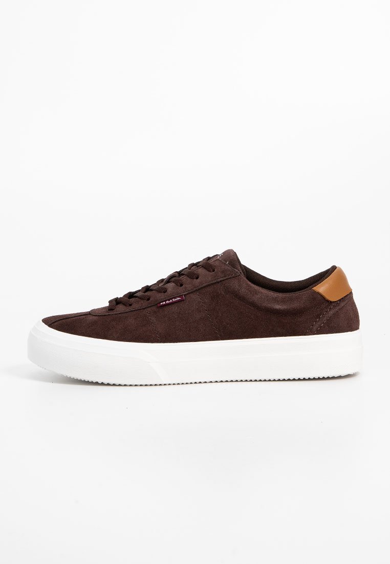 Brązowe zamszowe sneakersy z białą gumową podeszwą, brązowym skórzanym akcentem na pięcie i brązowymi sznurowadłami. Zawierają subtelne detale przeszyć.