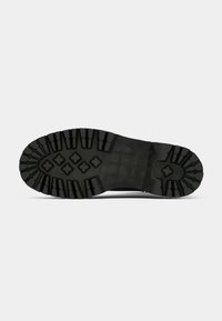 Black rubber sole with deep treads and a textured grip pattern. Features a flat heel and a reinforced toe area.