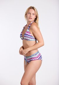 Bikini súprava s topom na zaväzovanie za krk a nízko strihanými nohavičkami, vyrobená z elastického materiálu s farebným cik-cak vzorom v modrej, ružovej a fialovej farbe.