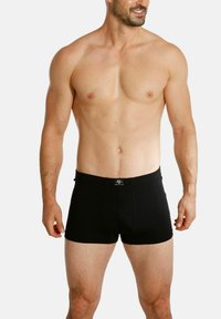 Black boxer briefs made from stretchy fabric, featuring a fitted design with a soft waistband and minimalistic stitching.