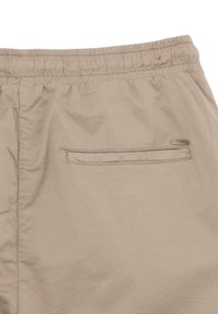 Pantaloni cargo beige con vita elasticizzata e una tasca posteriore singola con un sottile dettaglio di cucitura. Tessuto dalla consistenza liscia.