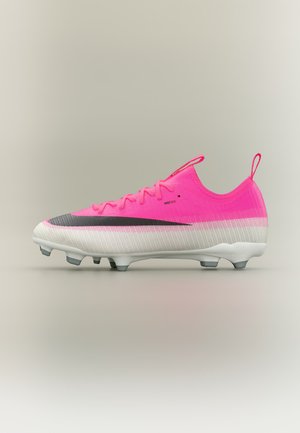 Chaussure de football rose vif et blanche avec le logo Nike noir, lacets noirs et crampons moulés conçus pour jouer sur terrain ferme.