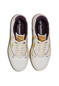 White and yellow athletic shoes with a textured leather upper, perforated detailing, and a dark purple fabric lining. Logo and branding visible.