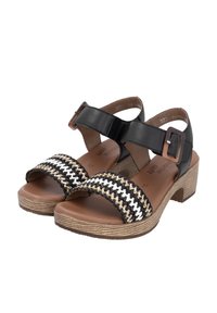 Black leather sandals with woven black, white, and tan straps, a block heel, and adjustable buckle closure. Textured tan insole.