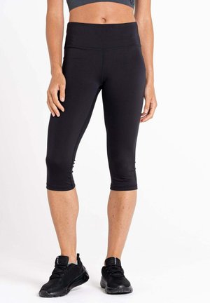 Schwarze Capri-Leggings mit hohem Bund, aus dehnbarem Material. Merkmale sind eine glatte Textur und ein knielanger Schnitt. Schwarze Sportschuhe.