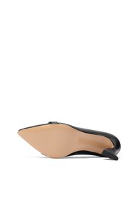 Scarpa nera in pelle con tacco alto e punta affusolata, dotata di una suola in gomma color nude, caratterizzata da un design minimalista e una texture liscia.