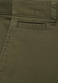 Khaki trousers featuring a smooth, textured fabric, with a back pocket and detailed stitching. The waistband shows a distinct weave design.