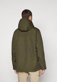 Giacca imbottita verde oliva con cappuccio, polsini elasticizzati e taglio dritto. Tessuto liscio con minimi dettagli di cucitura visibili.