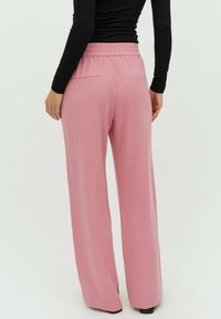 Hele roosad, laiad püksid pehmest materjalist, millel on elastne vöökoht ja kaks tagataskut. Disainis on sile tekstuur.