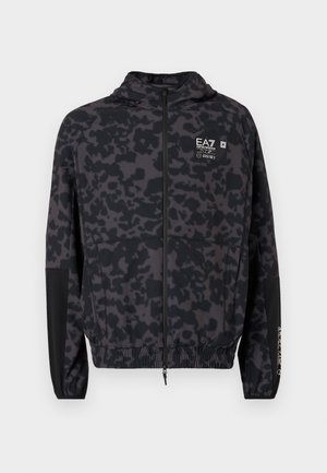 Veste à capuche noire avec un motif abstrait gris. Elle comporte une fermeture éclair, des poignets élastiques et un logo de marque sur la poitrine.