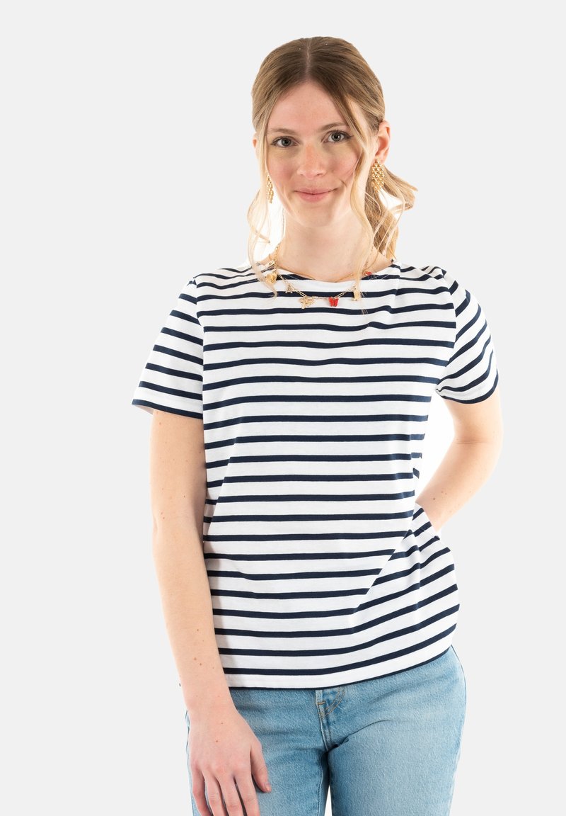 Camiseta a rayas con rayas horizontales en navy y blanco, mangas cortas, escote redondo, combinada con jeans de color azul claro.