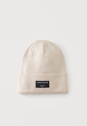 Beige gebreide muts met omslag en zwarte rechthoekige patch met de tekst "BJÖRN BORG STOCKHOLM 1956" aan de voorzijde in het midden.