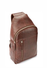 Sac à dos en cuir marron de forme arrondie, équipé d'une poche zippée à l'avant, d'une surface texturée, de finition en métal argenté et de poches latérales.