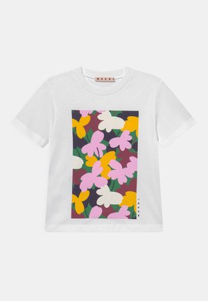 T-shirt in cotone bianco con stampa grafica di fiori multicolori nei toni di rosa, giallo e verde su uno sfondo scuro.