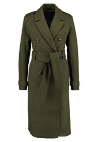 Olivgrüner, doppelt geteilter Trenchcoat mit einem Gürtel, Schulterklappen und geknöpften Manschetten. Hergestellt aus strukturiertem Wollmischgewebe.