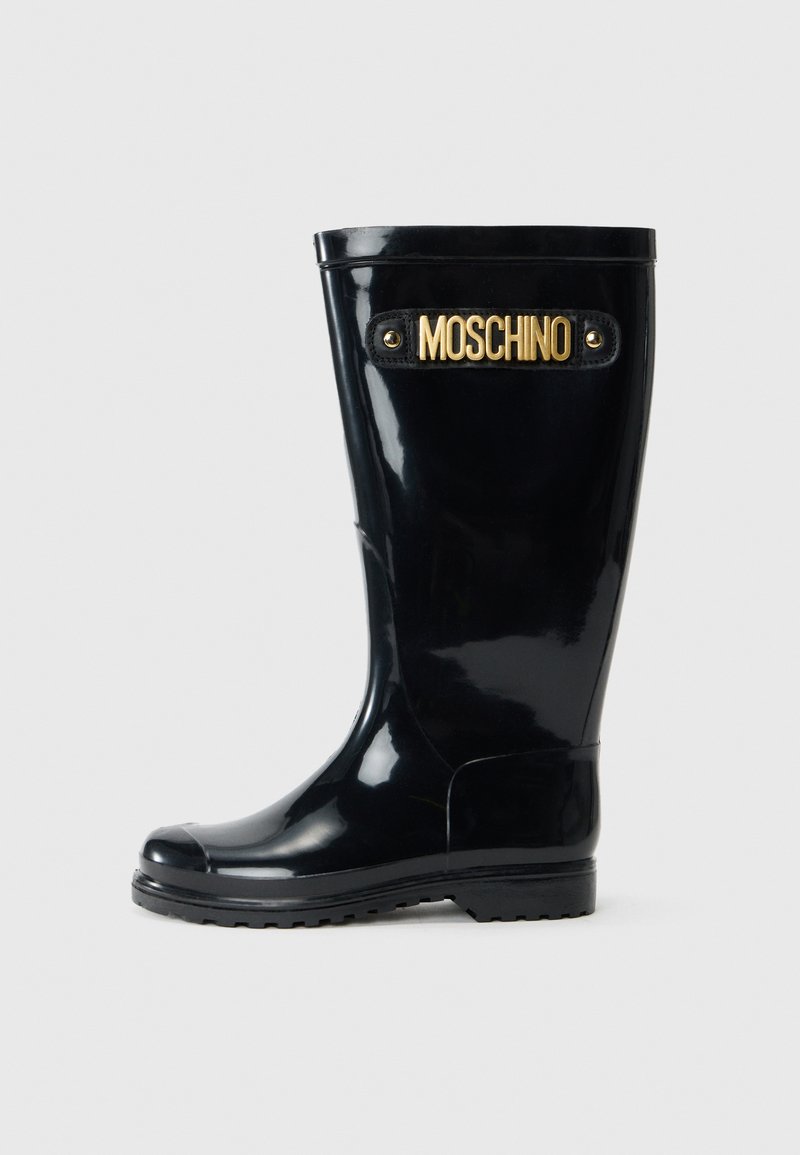 Black rubber rain boot with glossy finish, rounded toe, and a low heel. Features a gold "Moschino" logo and black accents.